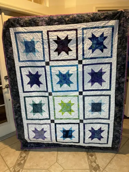 Handmade quilt with blue and green star blocks