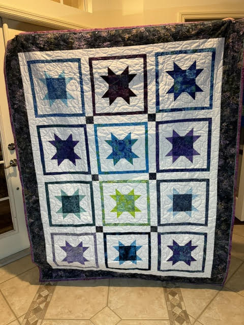 Colorful handmade quilt folded for donation