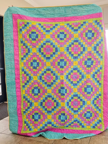 Colorful crocheted blanket with a repeating diamond pattern