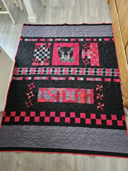 Red and black handmade quilt displayed on a table